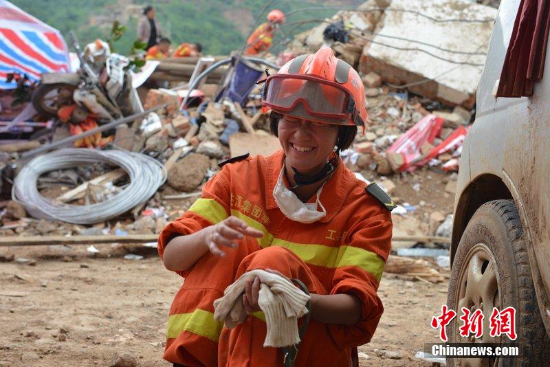 2014年8月5日，女兵在云南魯?shù)辇堫^山鎮(zhèn)廢墟中搜救被困者。