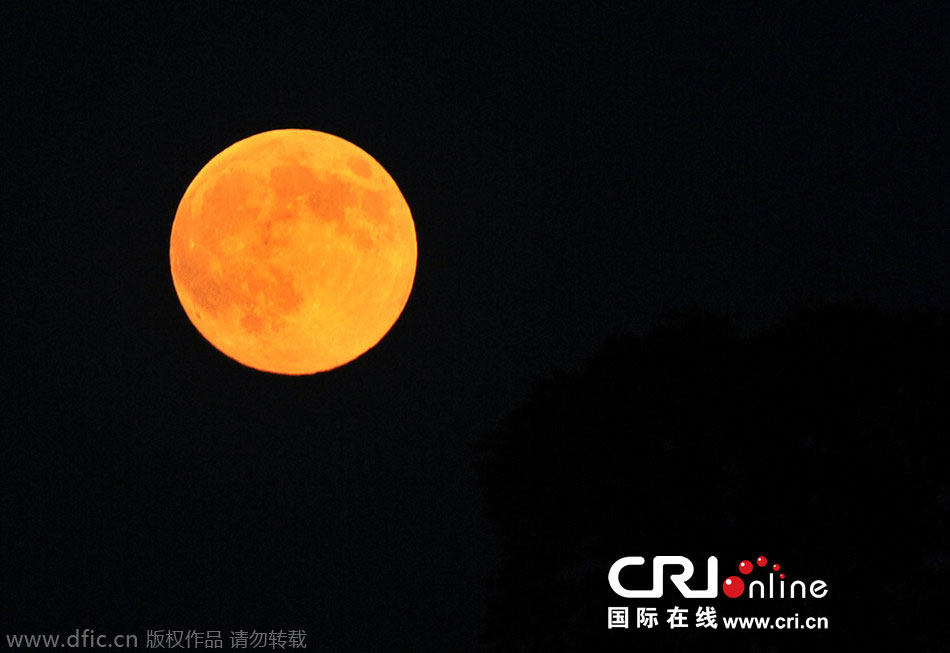 8月10日晚，一輪金燦燦的大月亮在遼寧省大連市東方升起。圖片來(lái)源：劉德斌/東方IC
