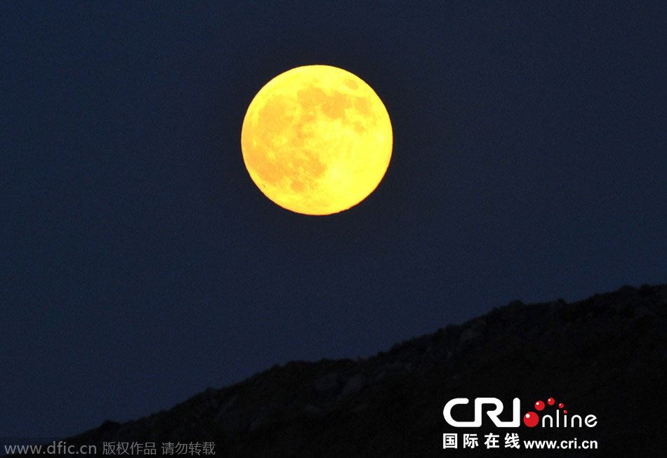 8月10日晚，一輪金燦燦的大月亮在遼寧省大連市東方升起。圖片來(lái)源：劉德斌/東方IC