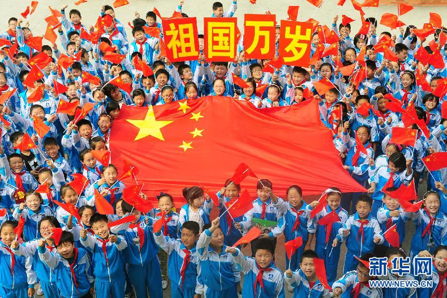 9月26日，安徽省阜陽市北城小學分校的學生與國旗合影。
