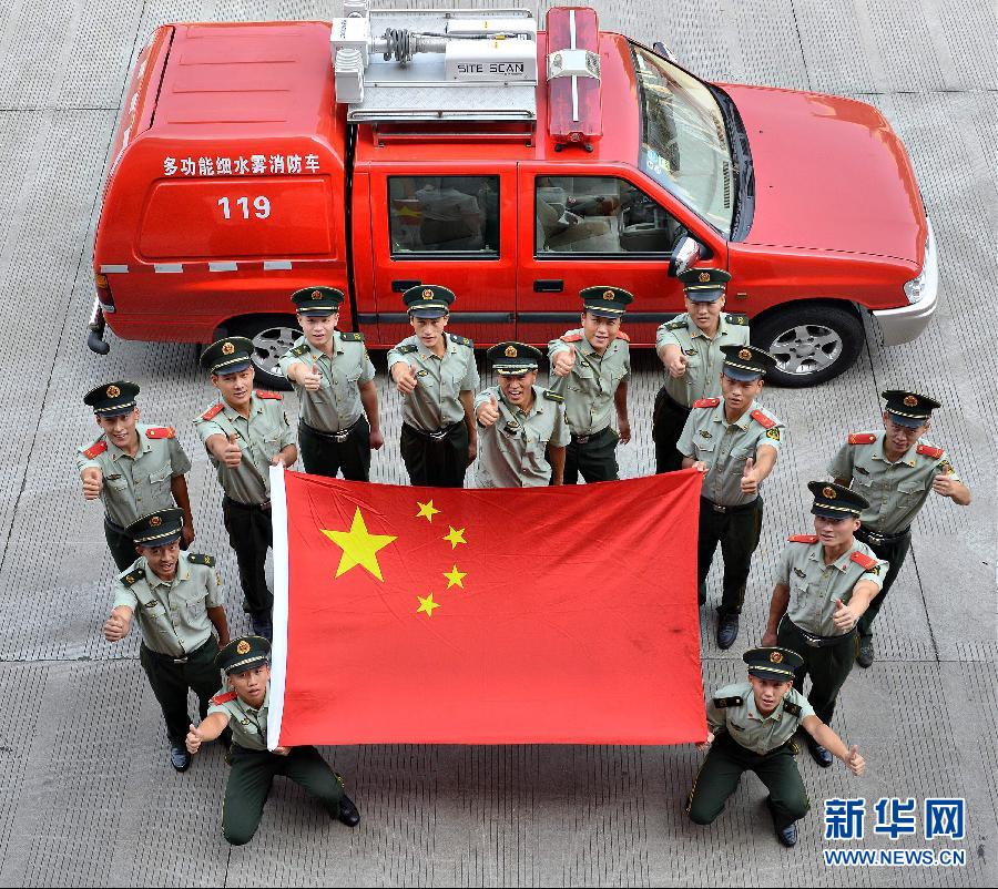 9月25日，武警浙江嘉興消防官兵與國旗合影。