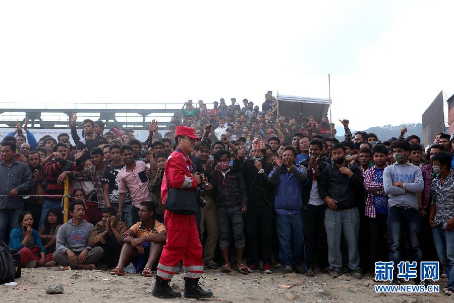 圍觀的尼泊爾民眾在中國國際救援隊成功搜救出幸存者后向搜救隊員歡呼致意。