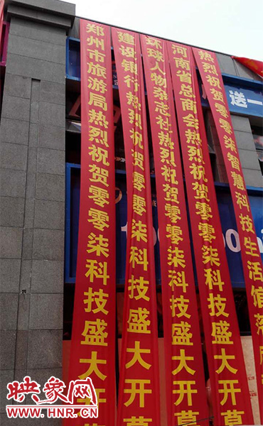 路邊一棟樓上懸掛著二三十條紅色條幅，全部是祝賀一家公司開業(yè)的。