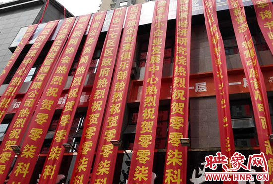 路邊一棟樓上懸掛著二三十條紅色條幅，全部是祝賀一家公司開業(yè)的。