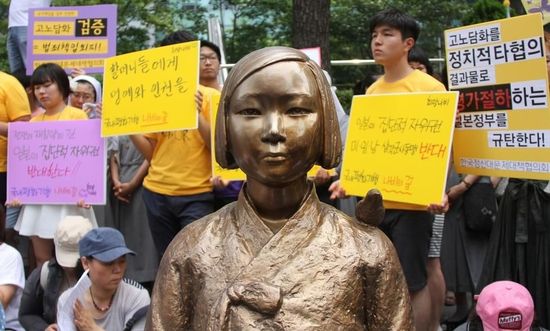 7月2日，在韓國首爾的日本駐韓國大使館前，民眾在慰安婦少女像旁手持標(biāo)語參加抗議活動(dòng)。