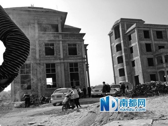 兩棟被舉報的違建樓下昨日一度聚集了超過百人，城管離開后逐漸散去。南都記者張志韜實習生宋超攝