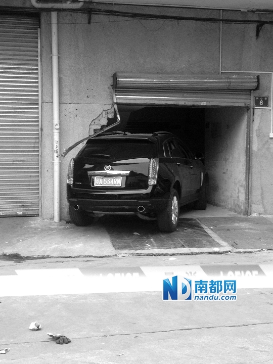 　昨日，凱迪拉克撞人后停在一倉(cāng)庫(kù)門口，車后有一攤血跡。 南都記者陳杰生攝