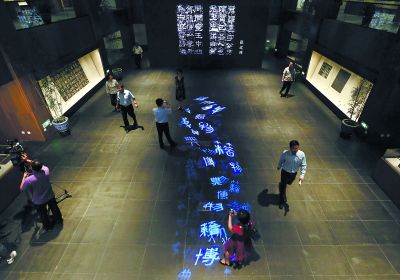 昨天，在國(guó)家典籍博物館內(nèi)，通過(guò)藝術(shù)投影技術(shù)呈現(xiàn)在展廳地面上的“漢字歷史長(zhǎng)河”，引得參觀者駐足觀看。