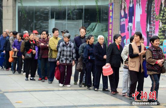 圖為10月28日，在江西九江市一家羊絨皮草服裝服飾博覽會現(xiàn)場，老人們正在頂著寒風(fēng)排隊等待領(lǐng)取10元代金劵。
