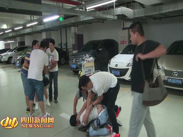 辦案人員在機(jī)場(chǎng)停車(chē)場(chǎng)抓獲胡某及其女友（警方視頻截圖）。