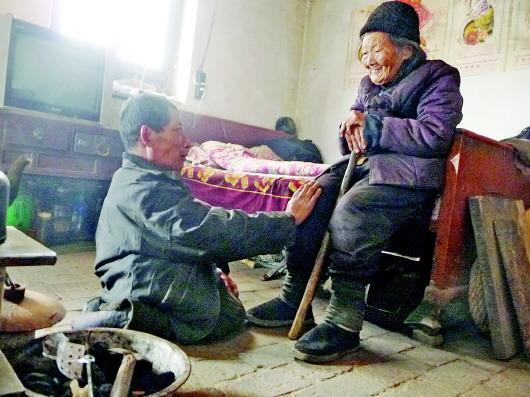 52歲的劉蘭山每天靠爬行照顧90歲的老母親。孫國(guó)祥 攝