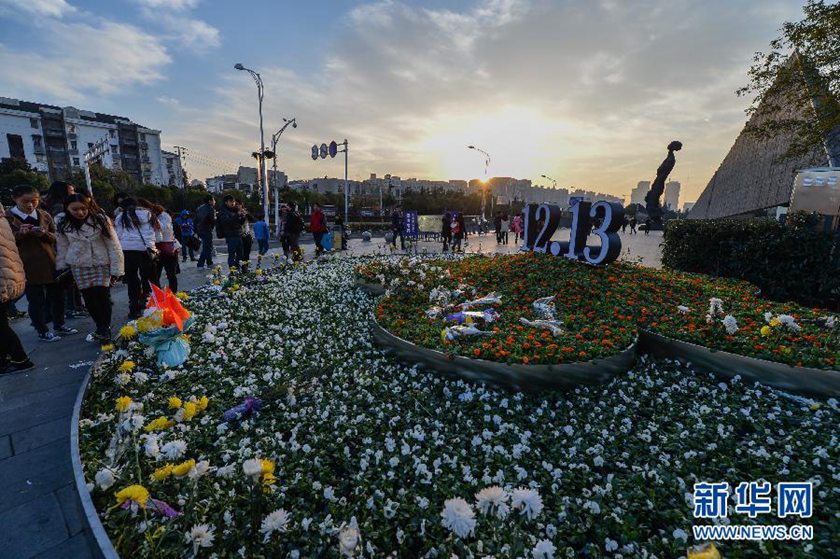 12月14日,觀眾在侵華日軍南京大屠殺遇難同胞紀(jì)念館前的“12·13”花壇上擺放鮮花祭奠遇難同胞。新華社記者 沈鵬 攝