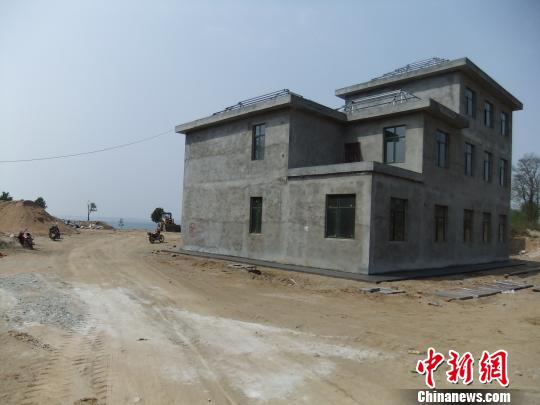 鴨河水庫(kù)庫(kù)區(qū)邊的新建別墅，一面墻上寫著“拆”，另一邊在加緊施工。吳揚(yáng)　攝